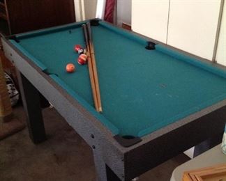Fooseball table and cue sticks.