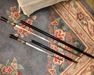 Two different sized ebony/inlaid walking sticks w/ brass trim...both with hidden swords!