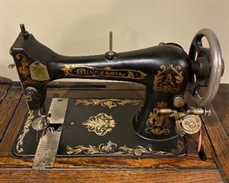 MINNESOTA A ANTIQUE SEWING MACHINE WITH CABINET