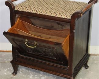 Antique coal bin style magazine cabinet. Carved front panel folds forward for magazine storage.  Raised on small Cabriole feet.  Upholstered cushioned top creating a small bench. (23”H x 21 1/2”W x 14”D)