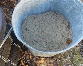 Metal garbage can half full with sand