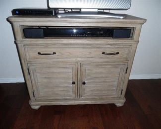 Greyish barn style TV Console by Haverty.  Yamaha suround sound system bar with speakers and woofer speaker.