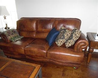 3 seat brown leather sofa. Has large worn spot on right inside arm.