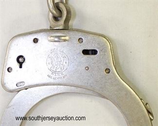 Lot 83: 3pc lot: Smith and Wesson Springfield, Mass. hand cuffs 007013 and Argus Manuf Co. Chicago, Ill. U.S.A. Pat. 1950757 Pat. 2066654 The Iron Claw Come Along with leather case
