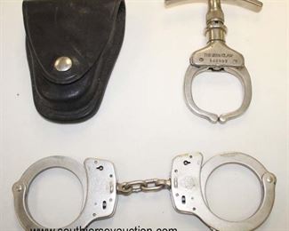 Lot 83: 3pc lot: Smith and Wesson Springfield, Mass. hand cuffs 007013 and Argus Manuf Co. Chicago, Ill. U.S.A. Pat. 1950757 Pat. 2066654 The Iron Claw Come Along with leather case