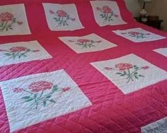 Cross stitch rose motif on hand made quilt