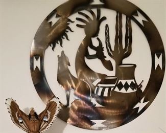 Very large round wall art of Kokopelli, pottery, sun, cactus and howling coyote.