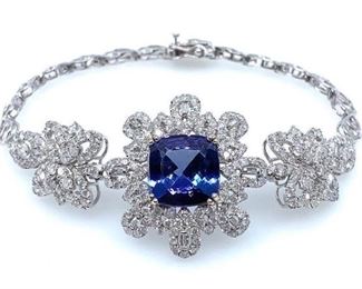 18k White Gold cast and assembled tanzanite and diamond bracelet. Bracelet features a center tanzanite set within a diamond set floral bezel supported by a semi-flexible diamond set floral ribbon transitioning into a matching white gold ribbon, terminating in a concealed clasp with twin safeties. Bright polish finish. Trademark is Orianne. Identified with markings of "18K".  One prong set square cushion mixed cut natural tanzanite, measuring 11.85 x 11.75 . 5.88mm, approximate weight 5.96ct., clarity is eye clean, type I, medium dark, very slightly grayish, violet blue color (GIA vB 6/3) cut is good. 233 prong set round brilliant and baguette cut diamonds approximate total weight of 233 Stones = 4.54ct. Graded in the setting. Clarity: 1-1 to 1-3 Color: G-I Total Weight of Colored Stones: 5.96ct. Total Weight of Diamonds: 4.54ct. Total Weight of Bracelet: 20.15gm  Length: 7.25 in Condition: New, good workmanship AIG Report included
