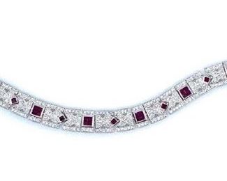 Stunning platinum ladies cast and assembled ruby and diamond bracelet featuring a series of ruby and diamond floral inspired links, completed by a concealed clasp with twin safeties. Bright polish finish with milgrain detailing throughout. Trademark is Orianne. Identified with markings of "PT 950".  40 bezel set square cut natural rubies measuring 2.00 x 2.00 x 1.30mm, approximate total weight of 2.97ct., clarity is slightly included, type II medium dark, moderately strong, slightly purplish red color (GIA slpR 6/4) cut is good. 288 bead set round brilliant cut diamonds approximate total weight of 288 Stones = 2.81ct. Clarity . VS-2 to SI-1 Color . Â E-G Total Weight of Colored Stones . 2.97ct. Total Weight of Diamonds 2.81ct. Total Weight of Bracelet . 38.50gm Length: 7.25 in. Condition: New, good workmanship AIG Report included.
