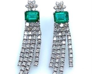 18KT white gold ladies cast and assembled emerald and diamond dangle earrings with screw backs. Each earring features an emerald with dangling diamond ribbon fringe, supported by a diamond floret post. Bright polish finish. Trademark is Orianne. Markings of "18K" Two prong set rectangular step cut natural emeralds, measuring 8.00 x 6.00 x 4.50mm. Approximate total weight of 3.45ct., clarity is heavily included, type III, medium dark, moderately strong, very slightly bluish green color (GIA vslbG 6/4). Cut is good. 100 prong set round brilliant cut diamonds approximate total weight of 100 Stones = 4.16ct.  Clarity . SI-2 to I-2 Color . F-H Total Weight of Colored Stones . 3.45ct. Total Weight of Diamonds . 4.16ct. Total Weight of Dangle Earrings . 13.60 gm  Length: 1.50 in. Condition: New, good workmanship AIG Appraisal included
