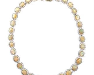 Polished, stamped and tested 14K yellow gold necklace mounted with 33 genuine opals and 792 genuine round diamonds. Opals weighing approximately 47.14 carats; diamonds weighing approximately 9.32 carats. The necklace measures 18 inches in length and is finished with a tension lock clasp and safety clasp. Total weight 41.0 grams. 33 Oval Cabochon Cut Opals, 10 x 8mm, Total Weight 47.14 carats 792 Brilliant Cut Diamonds, 1.3-1.4mm, 9.32 carats, Clarity 11-12, Color Grade G-H  Length: 18 in. Condition: New, excellent workmanship AIGL Appraisal Included
