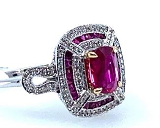 18KT white gold ladies cast ruby and diamond ring with 1.13ct ruby set within a diamond and ruby bezel, supported by a lattice gallery and mirroring diamond set shoulders, completed by a one millimeter wide band. Markings "18K 750".  One prong set cushion mixed cut natural ruby, measuring 6.50 x 5.20 x 2.90mm, approximate weight of 1.13ct. Clarity is moderately included, type II, medium dark, very slightly brownish, slightly purplish red color (GIA slpRÂ 6/3). Cut is good. 22 channel set square mixed cut natural rubies, measuring 1.30 x 1.00 x 0.75mm, approximate total weight of 0.22ct., clarity is slightly included, type II, medium dark, very slightly brownish, slightly purplish red color (GIA slpR 6/3). Cut is good. 96 prong set round brilliant cut diamonds exact total weight 96 Stones = 0.19ct. Clarity SI-1 to SI-2Color F-HTotal Weight of Stones 1.35ct. Total Weight of Diamonds 0.19ct. Total Weight of Ring . 4.00gm  Ring Size: 5.75-6 Condition: New, good workmanship AIG Appraisal In