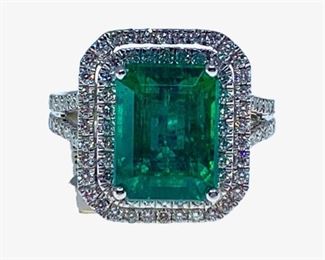 Platinum ladies cast emerald and diamond ring featuring emerald set within a diamond bezel, supported by an elaborate ribbed under gallery and diamond set shoulders, completed by a three millimeter wide band. Marked "PT950". Trademark is Orianne.  1 prong set emerald step cut natural emerald measuring 11.14 x 8.38 x 6.83mm exact weight 5.06ct. Clarity is moderately included, type III, dark, strong, green color (GIA G 7/5). Cut is good. 128 prong set round brilliant cut diamonds approximate total weight of 128 Stones = 0.99ct. Clarity SI-2 to I-1. Color G-H Total Weight of Stone . 5.06ct. Total Weight of Diamonds . 0.99ct. Total Weight of Ring . 8.70gm  Ring size: 6.5-6.75 Condition: New, good workmanship AIG Appraisal Included
