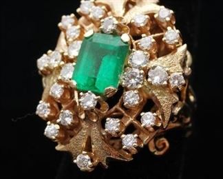 14K textured yellow gold ring with one emerald cut natural emerald approx 2.5 cts prong set, moderately included, type III, green color. Set with 28 prong set round brilliant cut diamonds approx 1.50 cts tdw, clarity VS-2 to SI-2, color G-H. Approx 17.38 grams.  Size 6. With appraisal.
