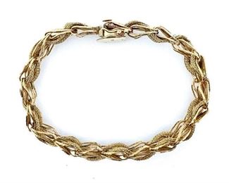 14K yellow gold braided link bracelet with floral design in the shape of flowers. Plunger clasp with figure eight safety. 20 grams. 7.75 inches Condition: Very good