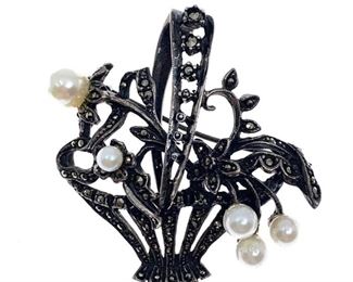 Charming sterling, marcasite and pearl brooch in the form of flowers in a flower basket. Marked .925 Length: 1.5 in. Condition: Good
