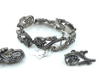 Three Piece Margot De Taxco Silver Suite. Three Piece Margot De Taxco Silver Suite, comprising bellflower and foliate scroll link bracelet, brooch and earrings (screw backs) each piece signed. 2.05 oz. troy total weight. Bracelet 7.5 in. l. Brooch 2.5 in. l. Earrings 1.25 in.l. Condition: Very good