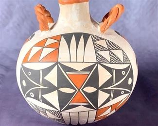 Acoma Pottery Two Handled Jar, B.Concho. Acoma Pottery Two Handled Jar, B.Concho, hand made spherical form with applied rope twist handles at shoulder, decorated in polychrome slip glaze with geometric and stylized patterns in brown and terracotta on cream slip glaze, signed B.Concho, Acoma, N.M.  7 in. h. x 7 in. w.  Condition: One tiny gouge in body, otherwise in good condition.
