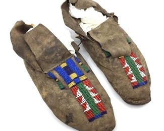 Pair of Native American Beaded Hide Moccasins, side sewn with rawhide sole, beaded down the center of the top with red, blue, yellow and green.  9.75 in.l.  Condition: brittle