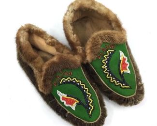 Pair of Beaded Souvenir Seal Skin Moccasins, Alaska. Pair of Beaded Souvenir Seal Skin Moccasins, Alaska, seal skin sides and soles, with fur trimmed ankle opening, beaded "Alaska" on green felt.  10 in.l.  Condition: Wear to seal skin soles, natural degradation due to age