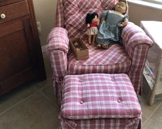 A few dolls and the cutest pink chair and ottoman 