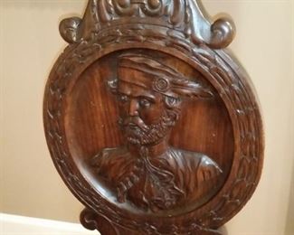 The carved back of the antique Italian hall chair