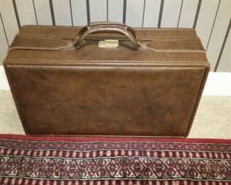 The smaller of two leather suitcases by Hartmann Luggage