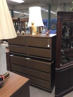 A nice tall dresser, with statuary and lamps.