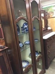 A tall cabinet with blue and white dishware.  