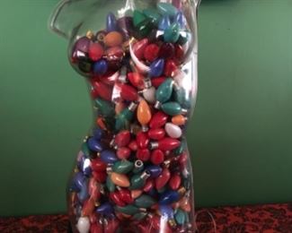 Lucite woman full of hundreds of Christmas bulbs