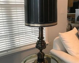 Vintage Stiffel Lamp. Mid-20th century table lamp in brass with black matte enamel accents and leaf detailing. On/off switch conveniently located on front/center base area.