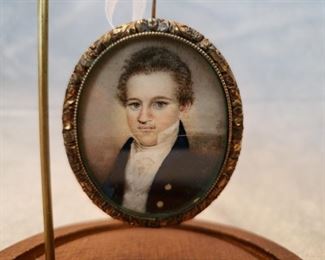 Miniature portrait on parchment paper in gold framed hanging in a domed watch holder