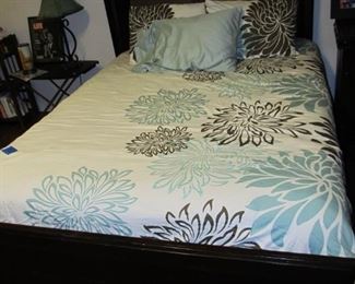 Designer bedding and a modern styled bed that can be a full-size or a queen.