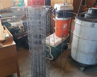 partial roll of wire fence and tomato cage