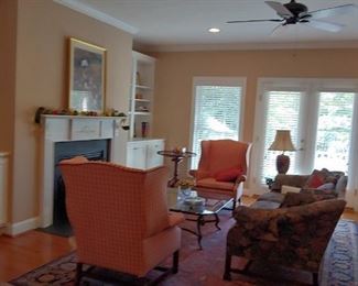 9x11 navy and deep reds wool rug. Upholstered wing back chairs fabric shows wear on arms. Antique upholstered couch. Glass and iron horse hoof table with matching end table.