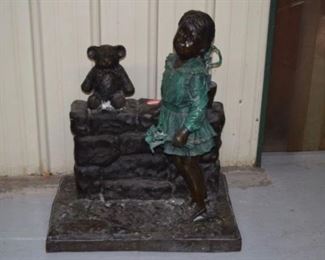 A Moreau Bronze Girl Standing by Block Wall