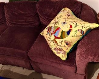 Cushy plum colored, velour round back couch. It’s about 6 1/2 feet long. Sits deep and super comfortable!