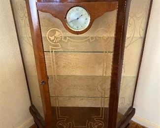 Small china cabinet with built in clock.