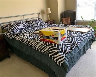 Queen Size Mattress and Box Spring, Blankets, Pillows and Sheets, Wing-back Chair, Wooden Nightstands, Faux Plants, and Table Lamps.