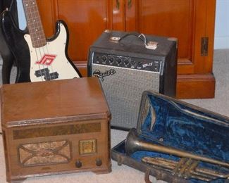 Vintage radio with turntable under lid. Fender guitar with amp.