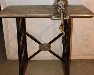 The De Muth Improved Dough Kneader and Biscuit Machine on a Marble Top Stand with a Wrought Iron Base. Machine has a Tiger Oak Cover