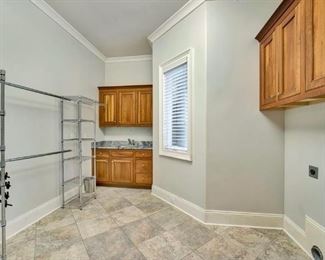 Large laundry room with shelving and cabinets