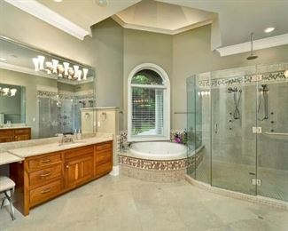 Huge master bath with jetted tub, dual vanities (one left and one right) and 3-head glassed in shower