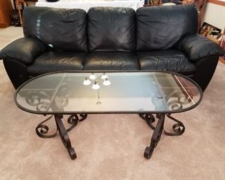 Leather sofa and glass top coffee table with ornate metal base