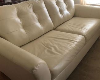 Cream leather sofa with matching chair is in excellent condition.  (Yes, it always had a protective covering.)