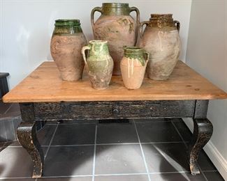 Collection of clay vessels on coffee table. Table measures 41 1/2" w x 19 1/2" h x 21 1/2" d.