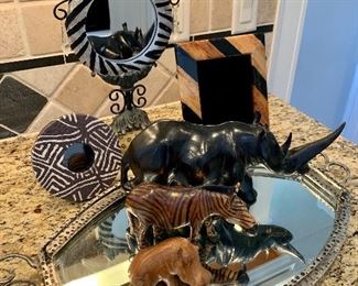 Collection of African, wooden carved animals on mirrored tray.