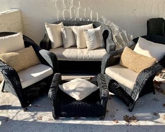 Black wicker set. Includes loveseat, 2 chairs, and ottoman. White cushions included.