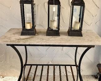 Stone top bar height table. Three indoor/outdoor candle lanterns.