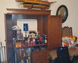 Small wooden entertainment center, mirror, bottle collection, and more. 
